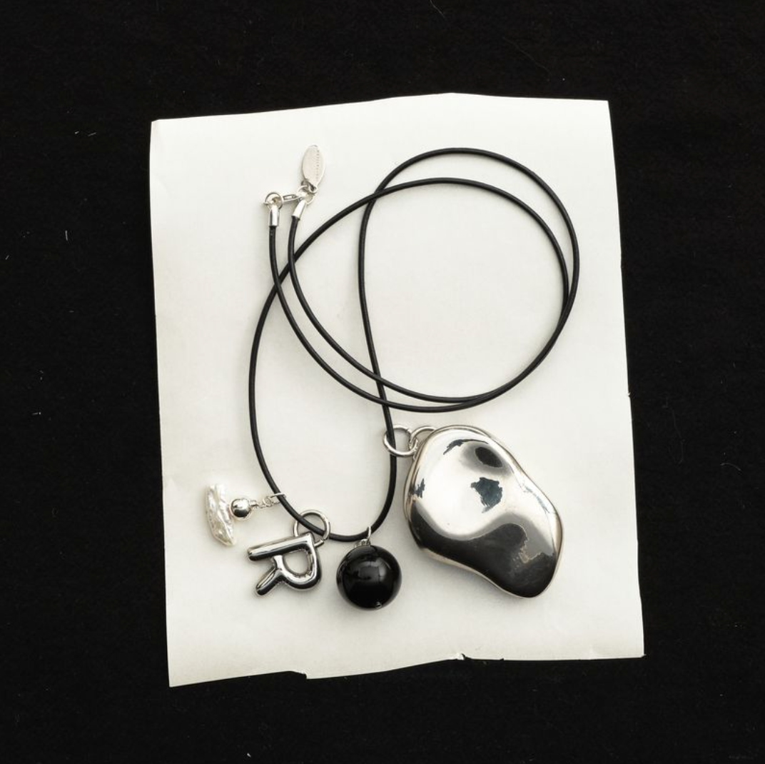 Everyday Talisman Necklace by Space of Time x Sea + Pattern: silver balm case on a beaded leather cord necklace with letter charm